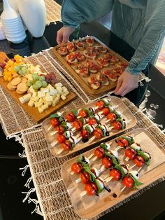 a table topped with trays of food covered in veggies