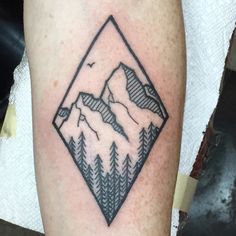 a black and white photo of a mountain with trees on it's side tattoo