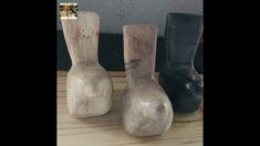 three vases sitting on top of a wooden table next to black shoes and a wall