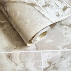 a roll of toilet paper sitting on top of a tiled floor