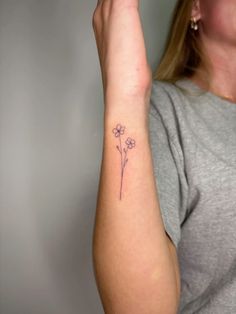 a woman with a flower tattoo on her arm