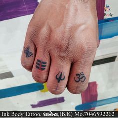 a person with two small tattoos on their fingers