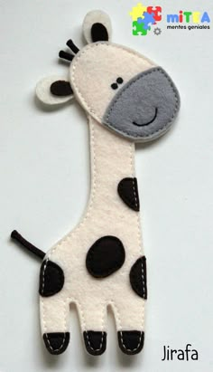 a close up of a giraffe made out of felt on a white surface