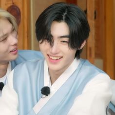 two people are smiling and one is wearing a blue kimono while the other wears a white shirt