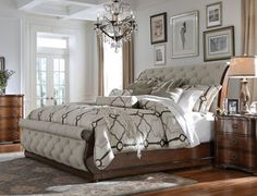 a bedroom with a bed, dressers and chandelier in it's center