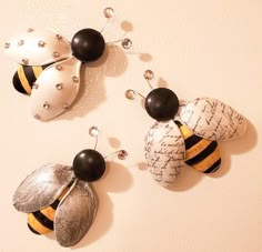 two bee earrings are hanging on the wall