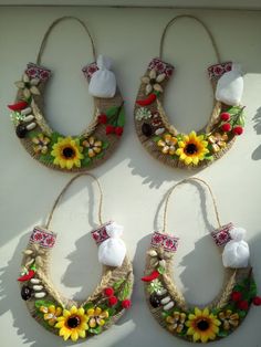 three wreaths made out of straw with sunflowers and shells hanging from them