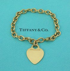 TIFFANY & Co. 18K Gold Heart Tag Charm Bracelet 8" Metal: 18K Yellow Gold Weight: 25.40 grams Length: 8". It could be adjusted to fit smaller wrist by moving the lobster clasp to any link on the bracelet Hallmark: "©TIFFANY&Co. 750" on the heart tag and "750" on the clasp Condition: Pre-owned, good condition, comes with Tiffany pouch, box, bag and ribbon Value: $6,200 Authenticity Guaranteed Tiffany Charm Bracelets Tiffany & Co., Tiffany Gold, Tiffany Setting, Gold Heart Bracelet, Tiffany Diamond, Modern Bracelets, Aquamarine Necklace, Heart Tag, Platinum Engagement Rings