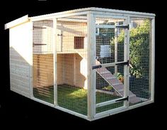 a large white chicken coop with stairs leading up to the top floor and door open