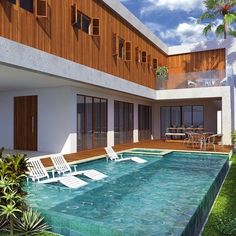 an empty swimming pool in front of a large house with wooden sidings and balconies