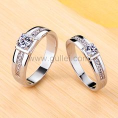 two white gold wedding rings with diamonds on the top and bottom, sitting next to each other