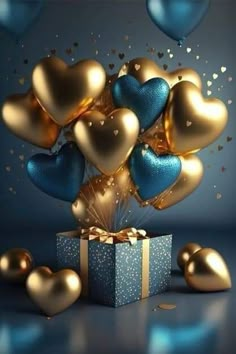 blue and gold heart balloons are coming out of a gift box