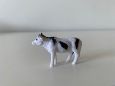 a small black and white cow standing on top of a table