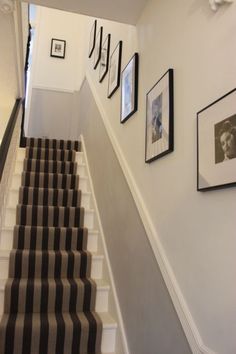 the stairs are lined with pictures and frames