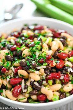 a bowl filled with beans, celery and other vegetables on top of a table