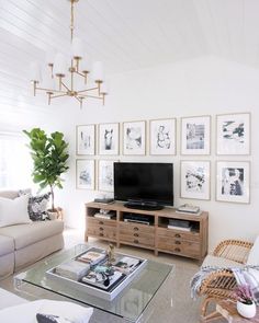 a living room filled with furniture and pictures on the wall