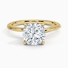 a yellow gold engagement ring with a cushion cut diamond