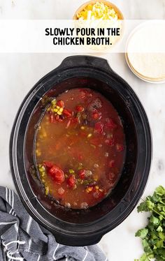 a slow cooker filled with soup and vegetables