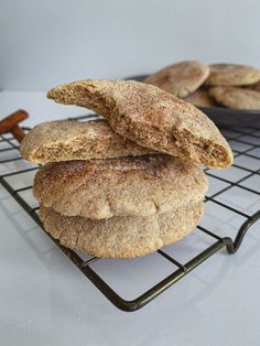 three cookies stacked on top of each other on a cooling rack with cinnamon sticks in the background