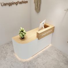 a white reception counter with a plant on top