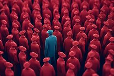 a person standing in front of a large group of red people with their heads turned to the side