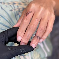 a woman's hand with two finger tattoos on it