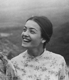 an old black and white photo of a woman laughing