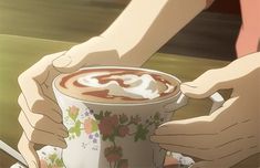 two hands holding a cup of hot chocolate in front of another person's hand