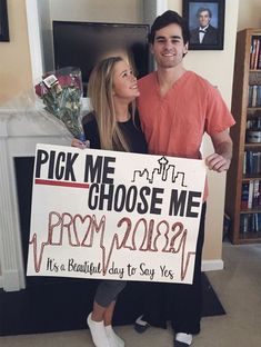 a man and woman standing next to each other holding a sign