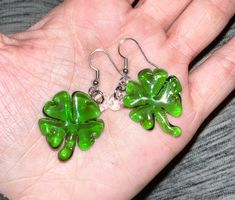 four leaf clover earrings in transparent green borosilicate glass. Handmade in Corning NY, finished with silver colored ear wires and plastic backings.  lucky me earrings aim to gravitate the wearer towards being more grateful to the little things in life. Corning Ny, Acorn Ornaments, Lucky Me, St. Patricks Day, Mini Ornaments, Clover Earrings, Four Leaves, Saint Patrick, Four Leaf