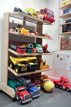 toy trucks and cars are lined up on shelves