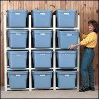 a man standing next to a wall filled with blue bins