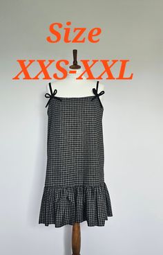 a black and white checkered dress on a mannequin with the words size xs - xxl above it