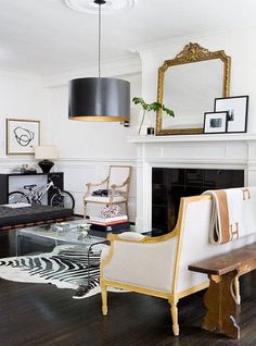 a living room filled with furniture and a fire place in front of a white fireplace