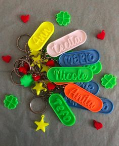 plastic name keychains with hearts and clovers on the table next to them