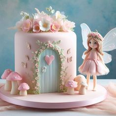 a pink cake with a fairy figurine next to it