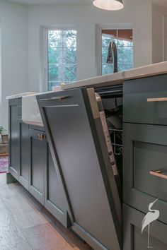 an open dishwasher sitting in the middle of a kitchen next to a sink