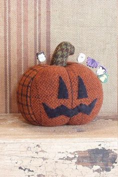 a knitted pumpkin sitting on top of a wooden shelf