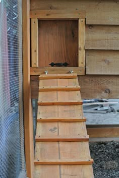 a bird house built into the side of a wooden building with a ladder leading up to it