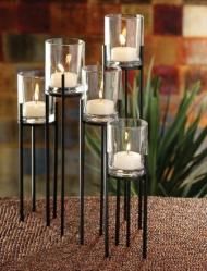 four candles are sitting in glass vases on a table