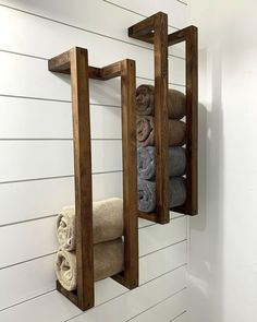 two wooden shelves holding towels and folded towels in a bathroom with white shiping walls