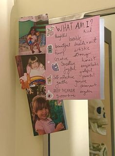 a pink sign hanging from the side of a bathroom wall next to a mirror with pictures on it