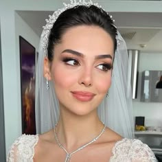 a woman in a wedding dress wearing a tiara and necklace with pearls on it