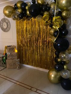 black and gold balloons are hanging on the wall