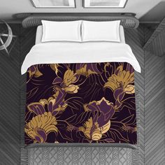 a bed with purple and gold flowers on it