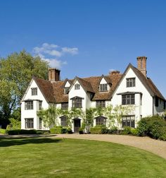 a large white house sitting on top of a lush green field