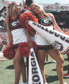 two cheerleaders hugging each other at a football game