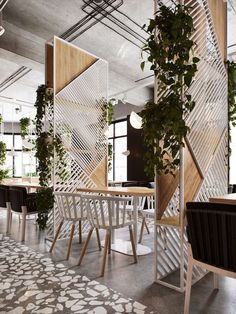 the interior of an office with plants growing on the walls and tables in the center