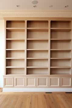 empty bookshelves in an empty room with hard wood floors