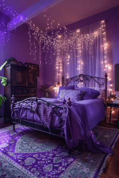 a bed with purple sheets and lights hanging from it's headboard in a bedroom